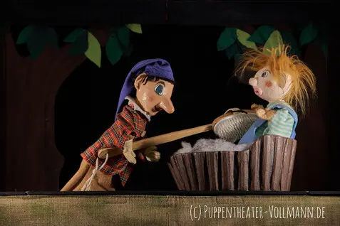 Kasper mit einer Badebürste wäscht eine lustige strubbelhaarige Figur in einer Badewanne.