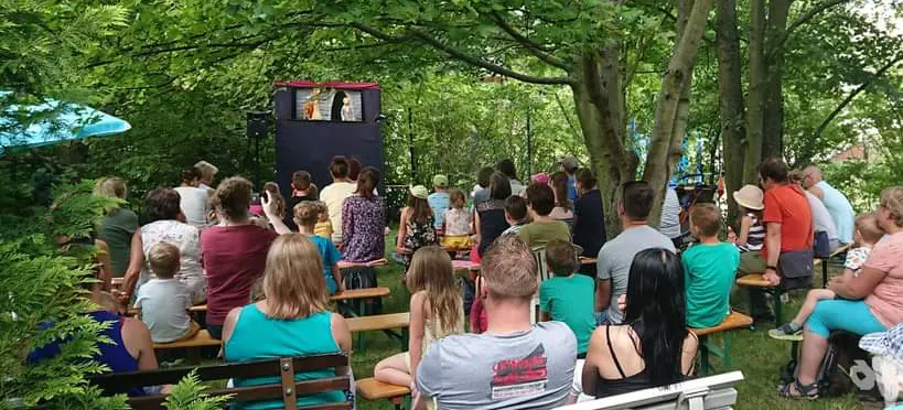 Familien vor eine Puppenbühne im Freien