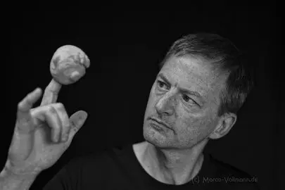 Ein Mann mit einem Schaumgummikopf auf der Hand